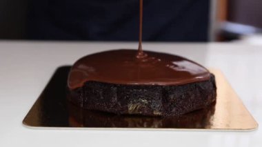 Pastanın üzerine çikolatalı ganache döken kadın fırıncı..