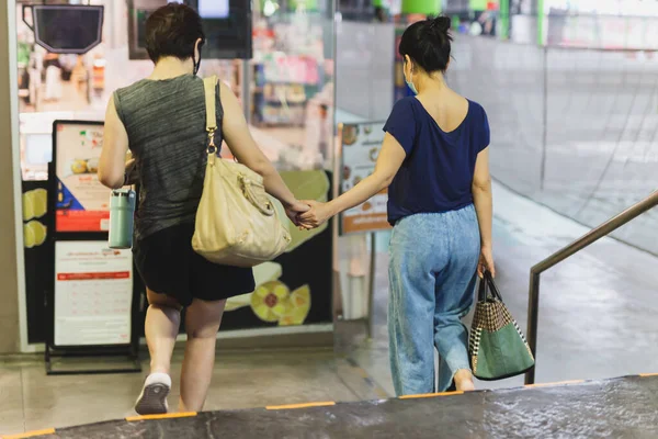 FemalecCasais de mãos dadas andando sobre as escadas. — Fotografia de Stock