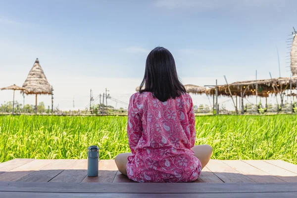 Femme assise sur le sol en bois avec thermos bouteille regarder beau paysage. — Photo