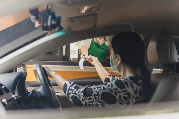 Woman customer paying bills with credit card at Starbuck Cafe drive through. — Stock Photo, Image