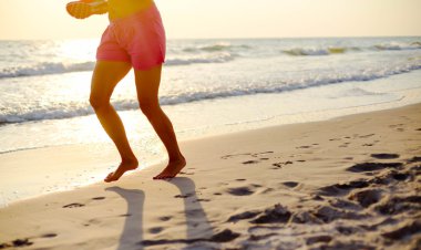 Kumsalda koşan kadın.