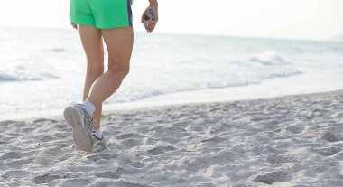 Kumsalda yürüyen bir kadın