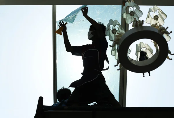 Unidentified  people wrappers tinting a glass house window in si — Stock Photo, Image