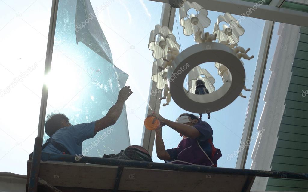 unidentified  people wrappers tinting a glass house window 