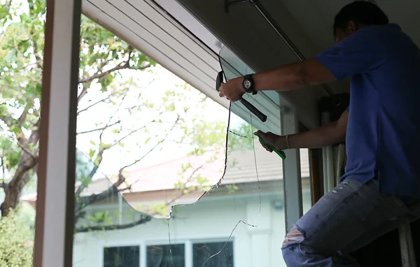 Repair man working on broken glass — Stock Photo, Image