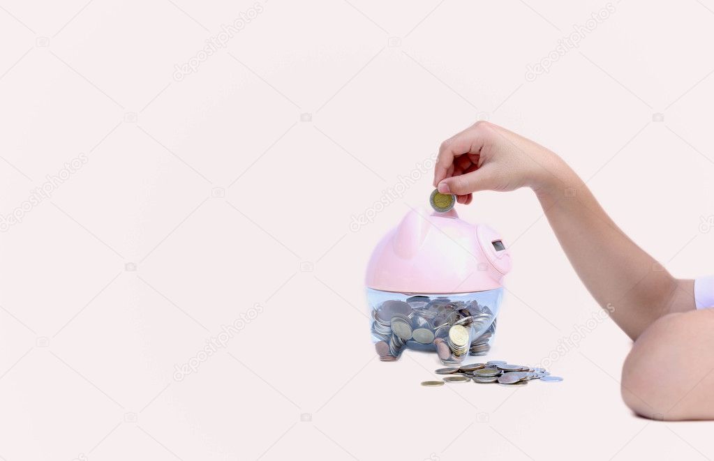 Child putting coin into big piggy bank