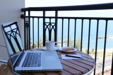 Balkon ve kahve okyanus ve bilgisayar laptop odaklanmak
