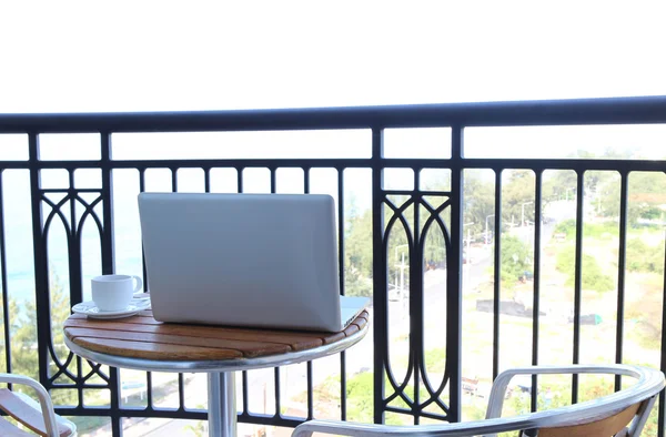 Computer laptop on balcony and coffee — Stock Photo, Image
