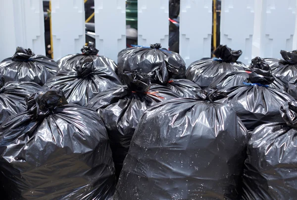 Zwarte vuilniszak op straat — Stockfoto