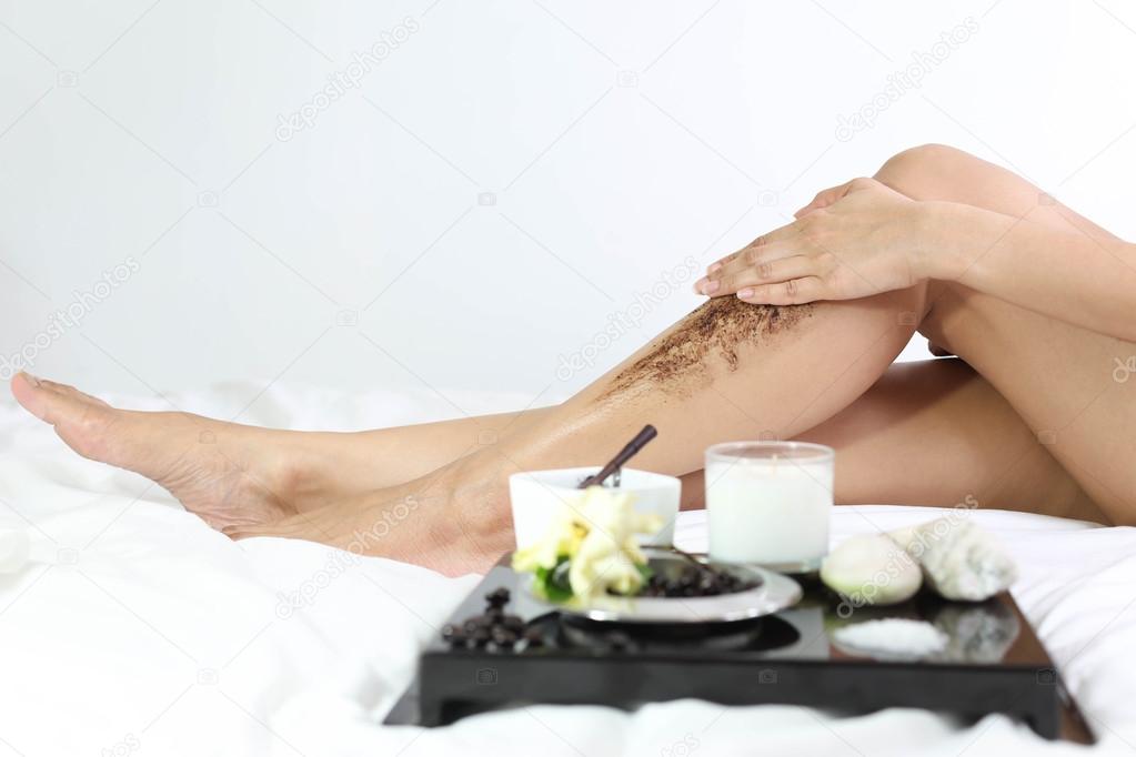 women cleaning skin with coffee grounds