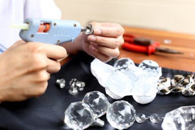 Kadın kristal lambalar tutkal tabancası ile sabitleme