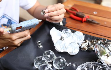 Kadın kristal lambalar tutkal tabancası ile sabitleme