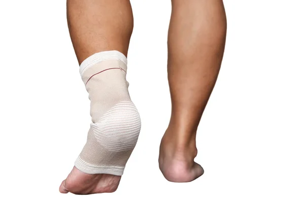 Tornozelo e pé lesionados envoltos em bandagem isolada — Fotografia de Stock