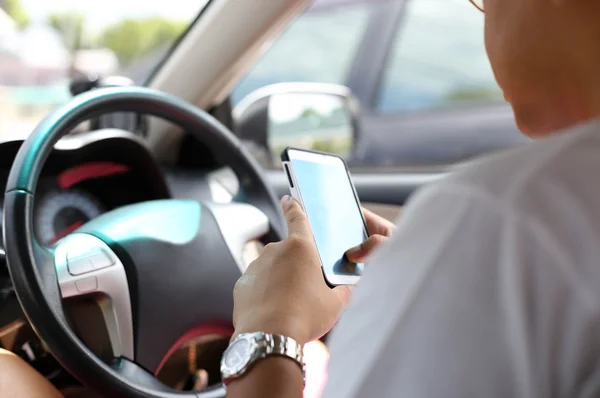 Ongeïdentificeerde man met behulp van slimme telefoon tijdens het rijden — Stockfoto