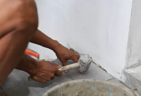 Homem que coloca telha com martelo de borracha — Fotografia de Stock