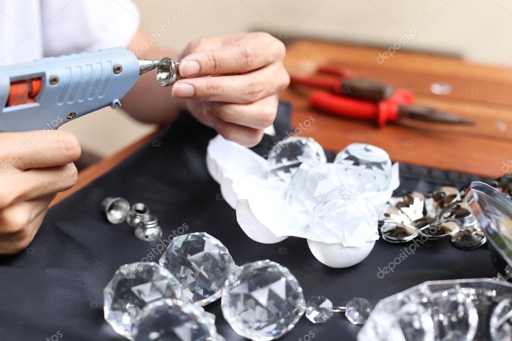 Woman fixing crystal lamps with glue gun