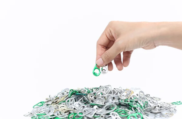 Hand holding aluminum cap can over a pile of cap can — Stock Photo, Image