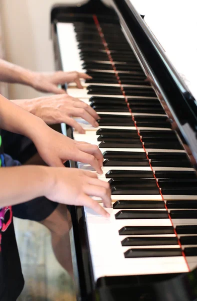 Отец учит маленького мальчика играть на пианино — стоковое фото