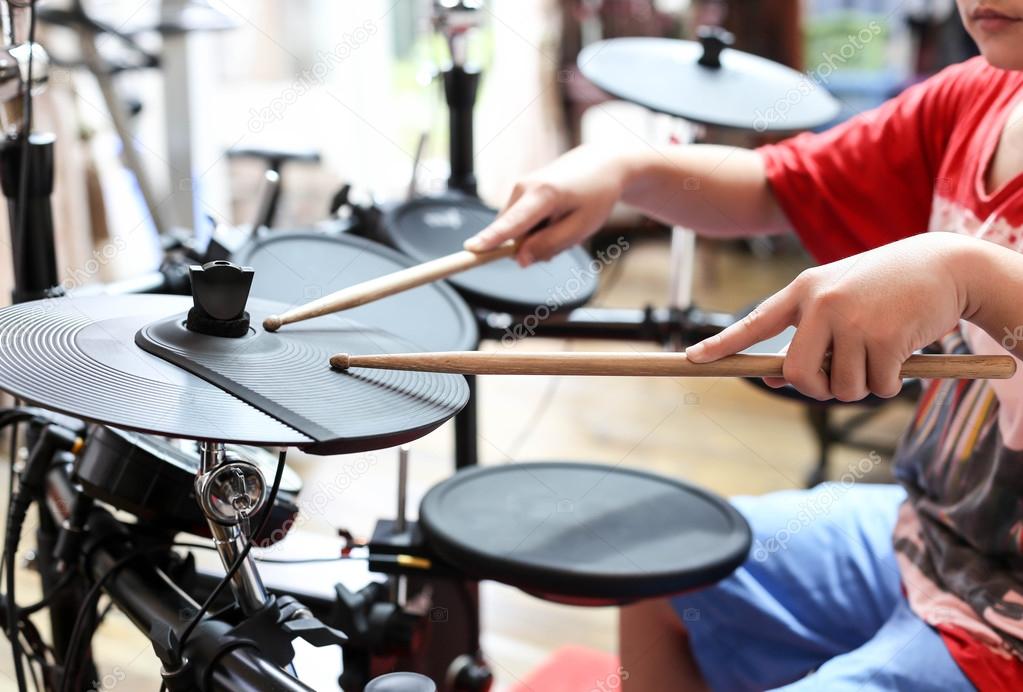 Unidentified Asian boy play electronic drum electronic drum