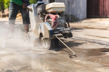 Benzin kullanan bir inşaat işçisinin kapanışı. Elektrikli beton testereli kaldırım