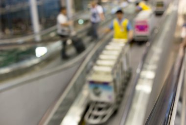 İşçi ile Bagaj arabaları üzerinde yürüyen merdiven havaalanında hareket bulanıklığı