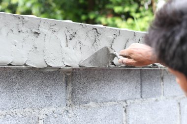 Asyalı çocuk el mala ıslak beton duvar ile kullanma