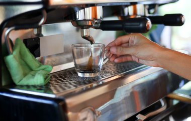 Barista el Kupası tutarak onun kahve hazırlar 