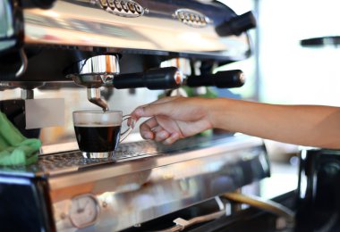 Barista el Kupası tutarak onun kahve hazırlar 