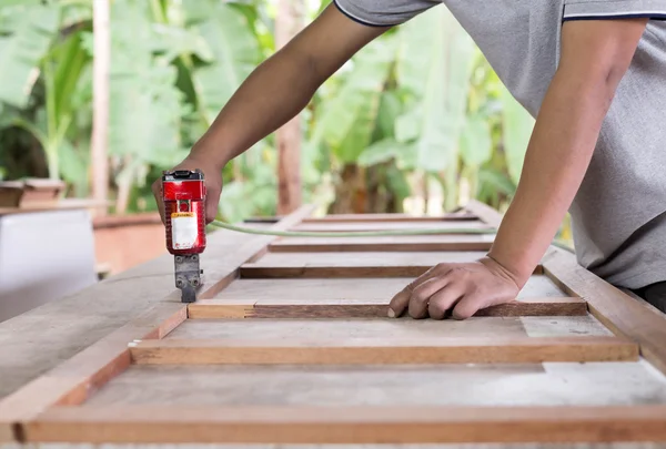 Asia timmerman gebruiken lucht-pistool voor make een meubilair — Stockfoto