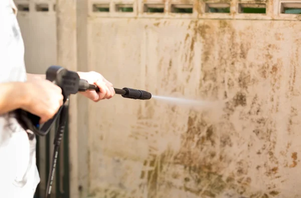 Frau putzt Wehwehchen mit Hochdruckwasserstrahl — Stockfoto