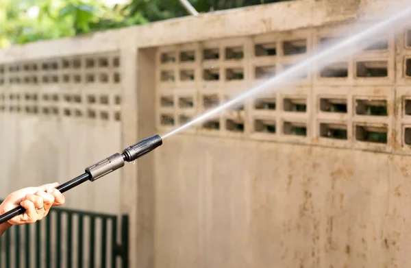 Vrouw schoonmaken waill met hoge druk waterstraal — Stockfoto