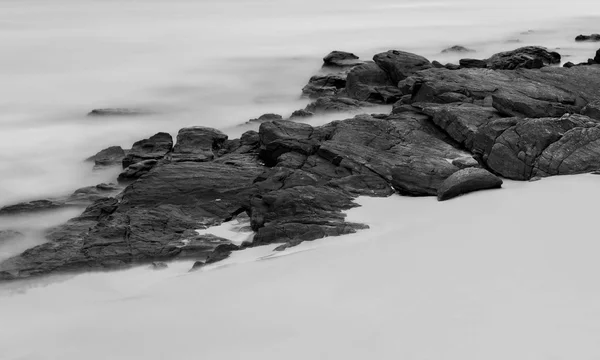 Hosszú expozíció a tengeri sziklák és a fehér homok — Stock Fotó