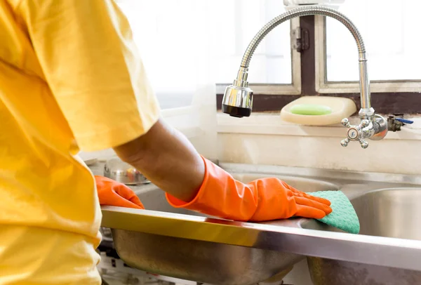 Hand met Oranje handschoen aanrecht schoonmaken — Stockfoto