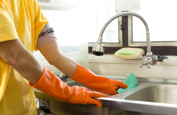 Hand met Oranje handschoen aanrecht schoonmaken — Stockfoto