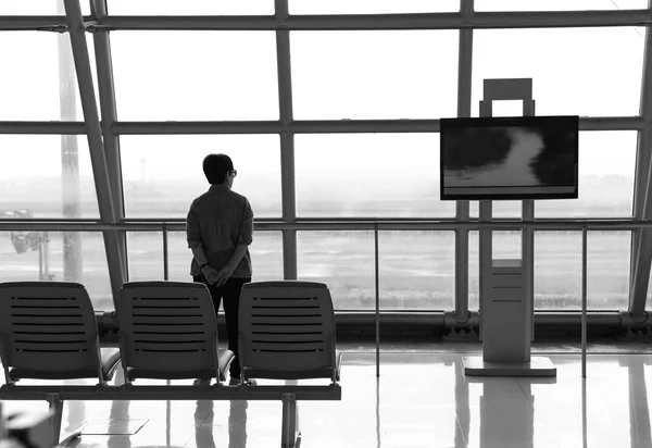 Focus on the chair back view of woman standing near the window o — Stock Photo, Image