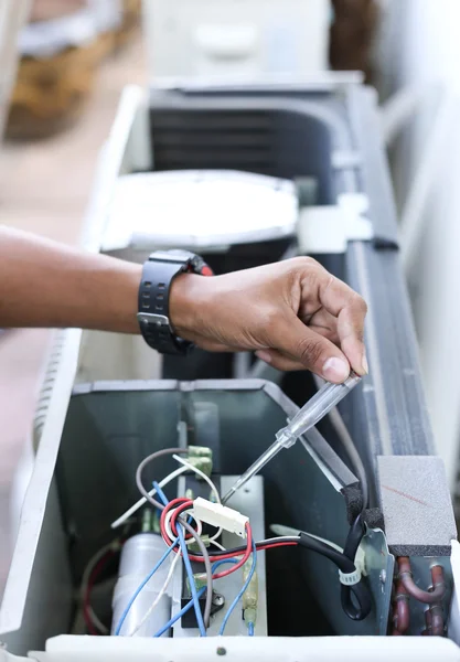 Eletricista mão segurando um detector em um elétrico — Fotografia de Stock
