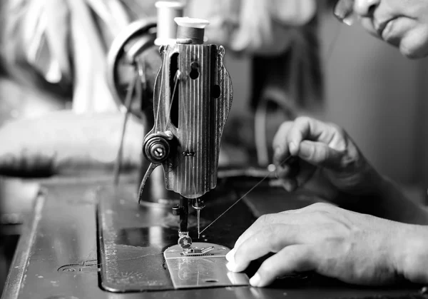 Женщина вручную втыкает иглу в иглу швейной машинки — стоковое фото