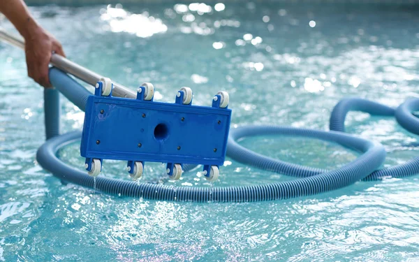 Homem segurando um equipamento para limpeza da piscina — Fotografia de Stock