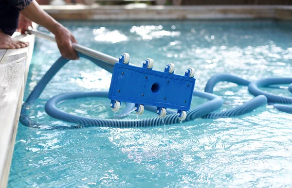 Uomo in possesso di un'attrezzatura per la pulizia della piscina — Foto Stock