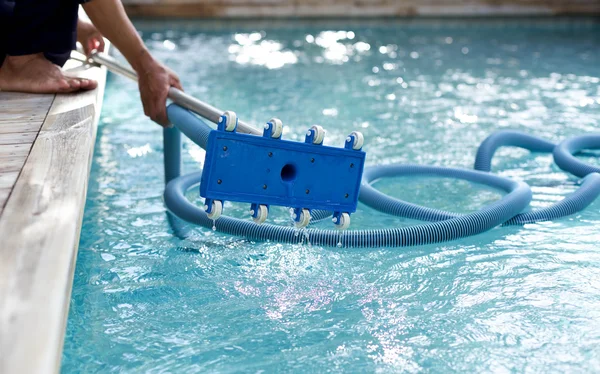 Uomo in possesso di un'attrezzatura per la pulizia della piscina — Foto Stock