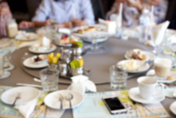 Blurry group of people after having food and cake leftover — Stock Photo, Image