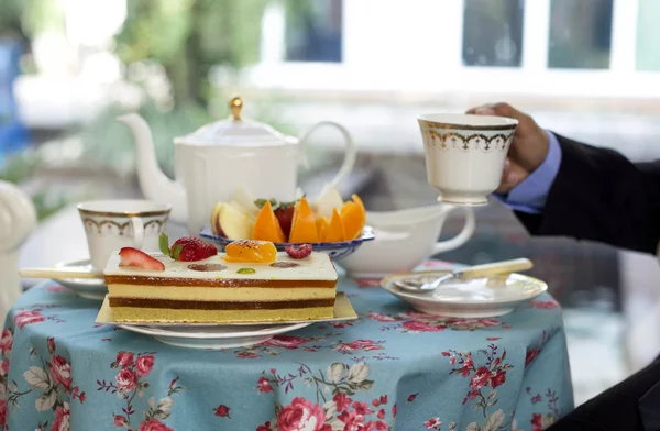 Empresario tomando té con tarta y fruta fresca —  Fotos de Stock