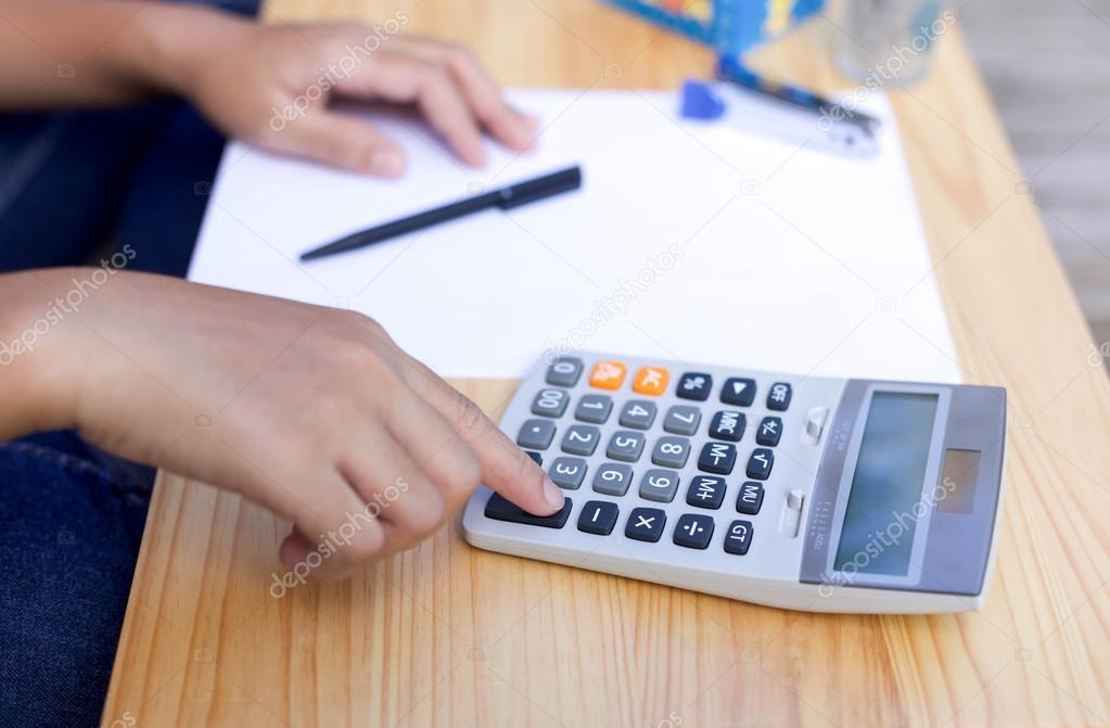 Businesswoman's working hand on calculator