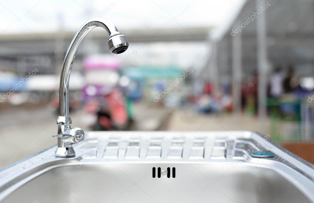 Water tap on stainless steel kitchen sink 