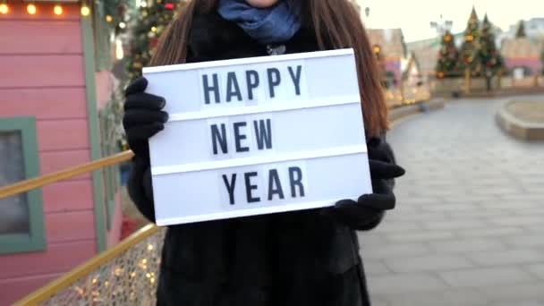 Felice anno nuovo segno in primo piano. Ragazza in pelliccia nera augura a tutti nuovo anno — Video Stock