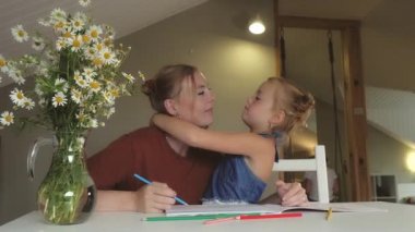 Anne kızına resim yapmayı öğretiyor.