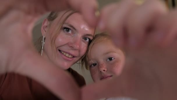 Мать и дочь показывают символы сердца своими руками — стоковое видео