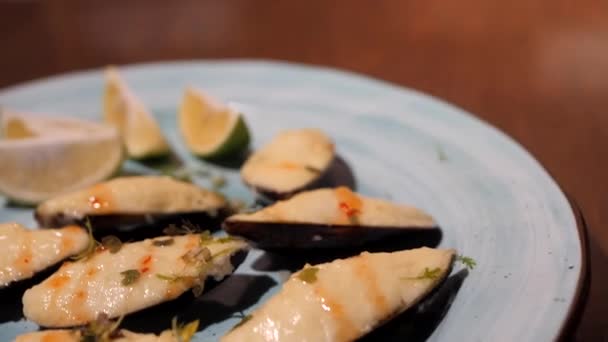 Finom kagylóféle sajttal, gyógynövényekkel és lime szeletekkel. — Stock videók