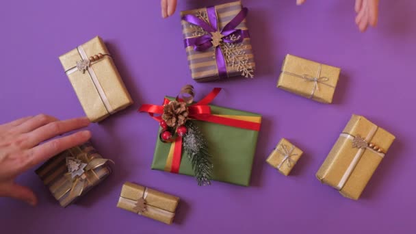 Kéz fogja a karácsonyi ajándékokat és kiviszi őket a keretből.. — Stock videók
