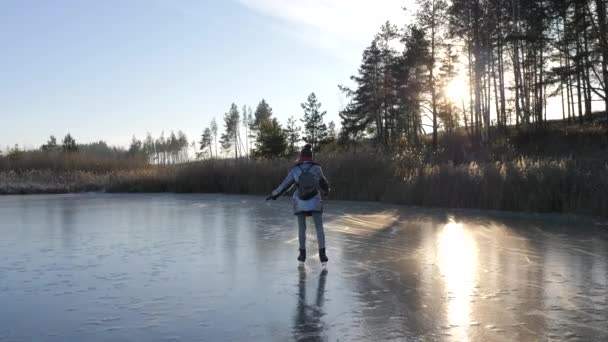 Dziewczyna jeździ na łyżwach po zimowym jeziorze. Zajęcia na świeżym powietrzu zimą. — Wideo stockowe